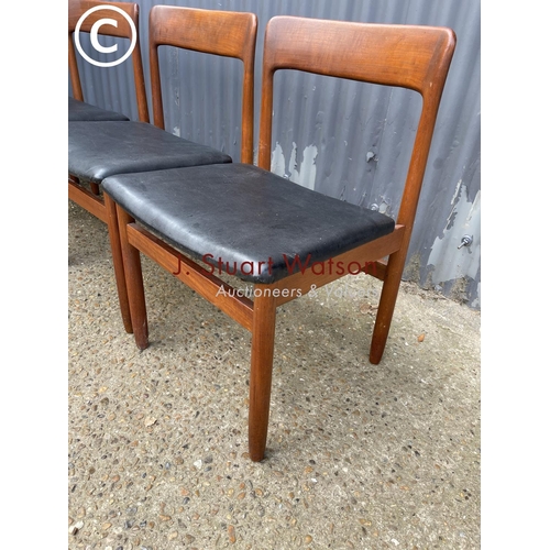 119 - A set of four danish style teak dining chairs with black vinyl seats