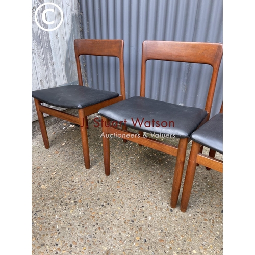 119 - A set of four danish style teak dining chairs with black vinyl seats