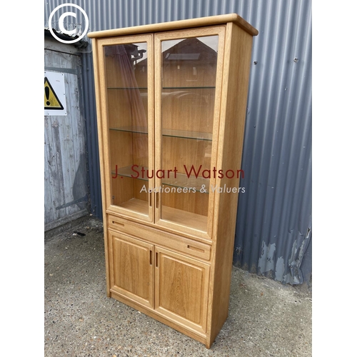 124 - A teak glazed bookcase cabinet with drawer