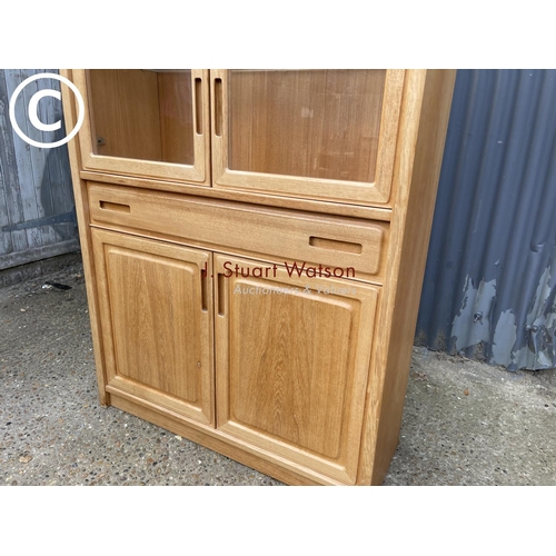 124 - A teak glazed bookcase cabinet with drawer