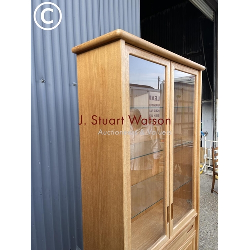 124 - A teak glazed bookcase cabinet with drawer