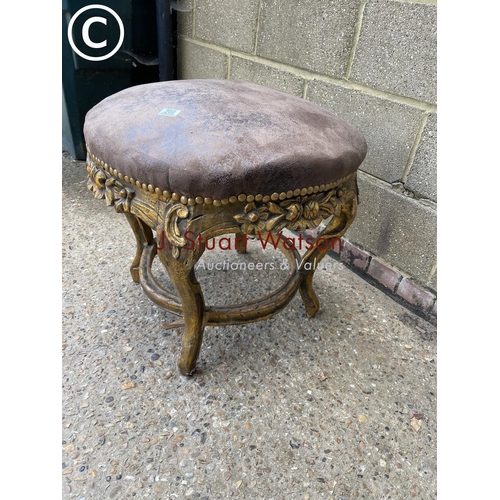 200 - A gold gilt circular stool / seat with brown leather top