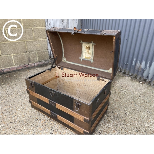 258 - A vintage oak bound dome top trunk with decoration to interior