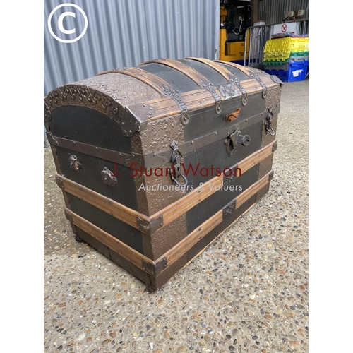 258 - A vintage oak bound dome top trunk with decoration to interior