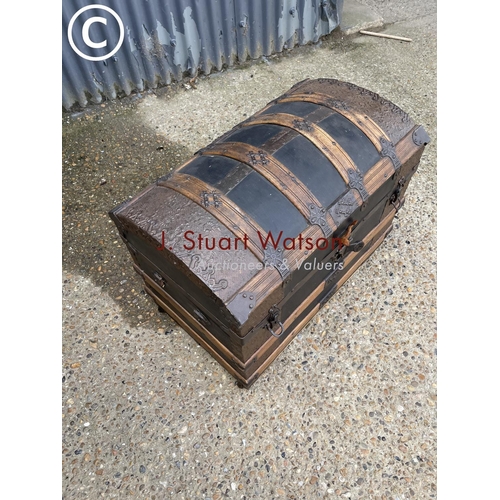 258 - A vintage oak bound dome top trunk with decoration to interior