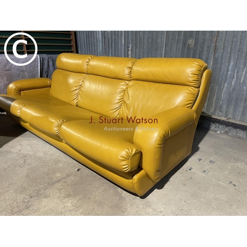 63 - A mid 20th century mustard coloured vinyl three piece lounge suite