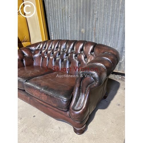 64 - A brown leather chesterfield style two seater sofa