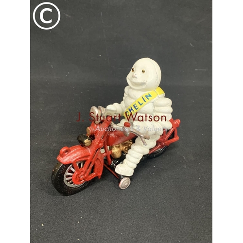 712 - Cast Iron Michelin man on motor bike , height 17cms