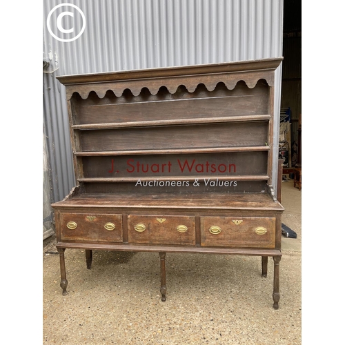 99 - An early oak three drawer dresser with plate rack top 187cm wide