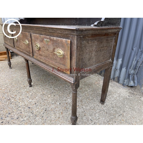 99 - An early oak three drawer dresser with plate rack top 187cm wide