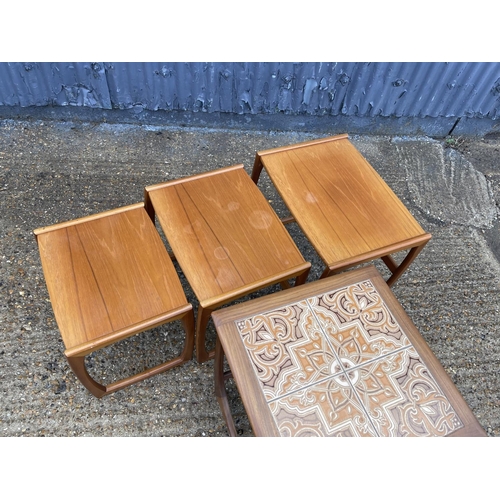 131 - A teak nest of three together with a g plan tile top table