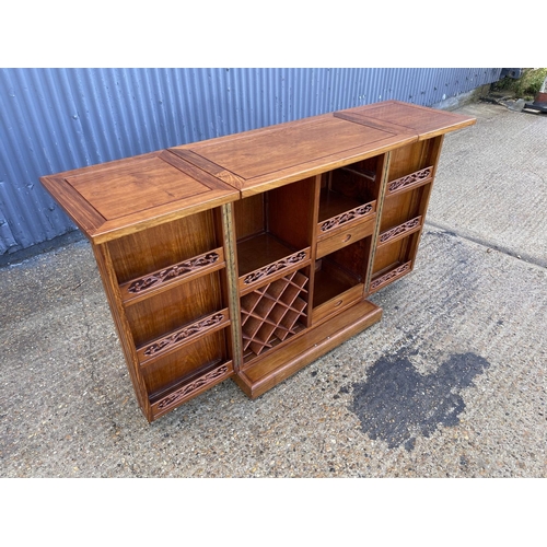 133 - An oriemtal style hardwood bar with fold over top and ornate  cocktail and drinks storage compartmen... 