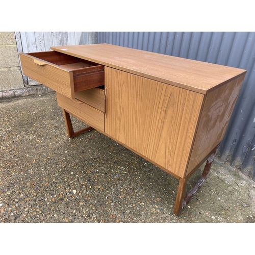 180 - A compact teak effect three drawer sideboard