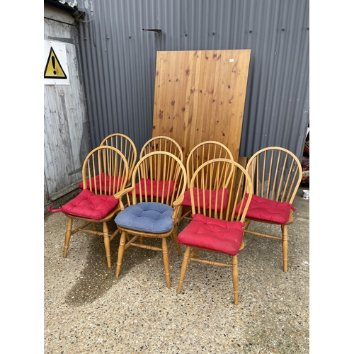 19 - A modern pine rectangular dining table together with seven stick back pine dining chairs 100x180