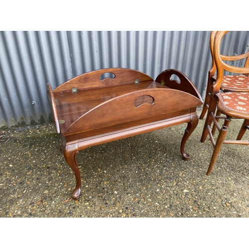 192 - A mahogany butlers style tray table together with two balloon back chairs