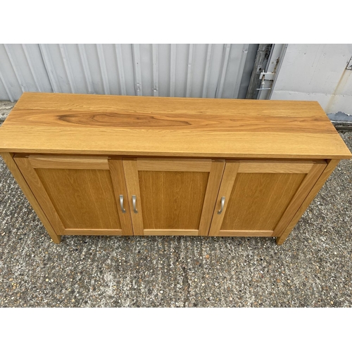 209 - A modern light oak three door sideboard