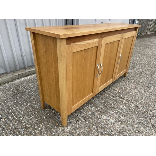 209 - A modern light oak three door sideboard