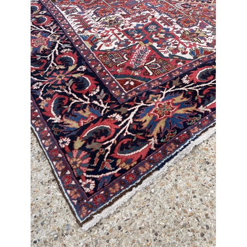 22 - A fine quality Heriz red, blue and white pattern carpet 404x290 cms