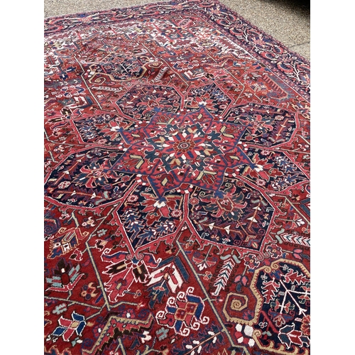 22 - A fine quality Heriz red, blue and white pattern carpet 404x290 cms