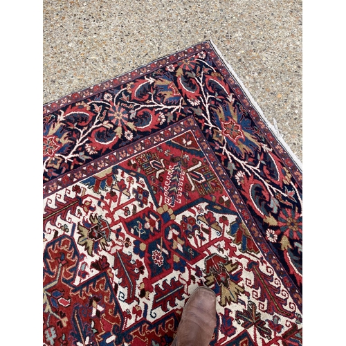 22 - A fine quality Heriz red, blue and white pattern carpet 404x290 cms