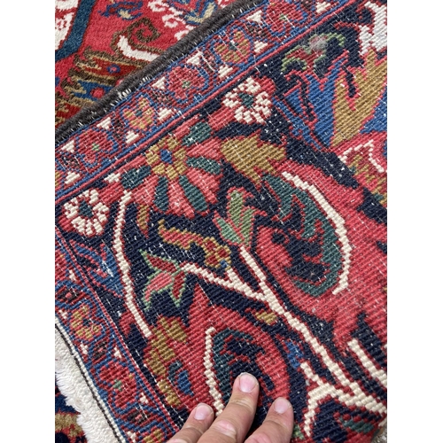 22 - A fine quality Heriz red, blue and white pattern carpet 404x290 cms