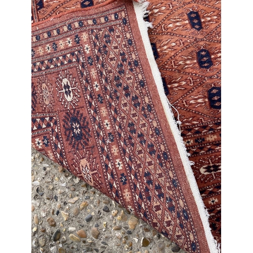 23 - A red oriental pattern rug