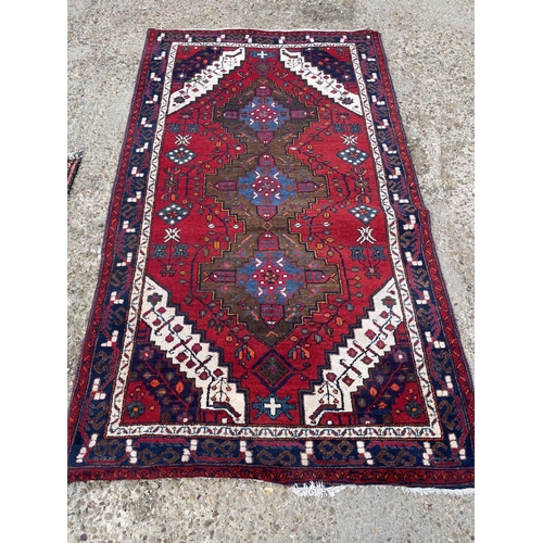 25 - A large red white and blue pattern rug 230x130