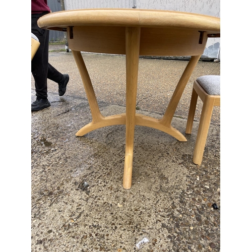 254 - A modern light oak oval dining  table together with four chairs