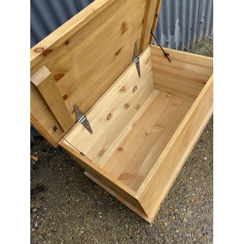 257 - A solid pine blanket box chest together with a slim pine bookcase