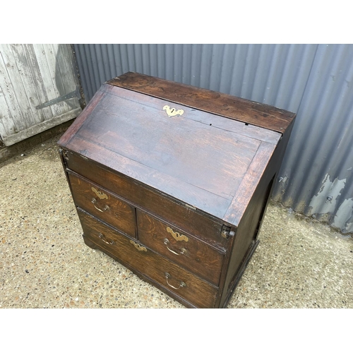 282 - A Georgian oak bureau, fitted to the interior with well. Three drawers