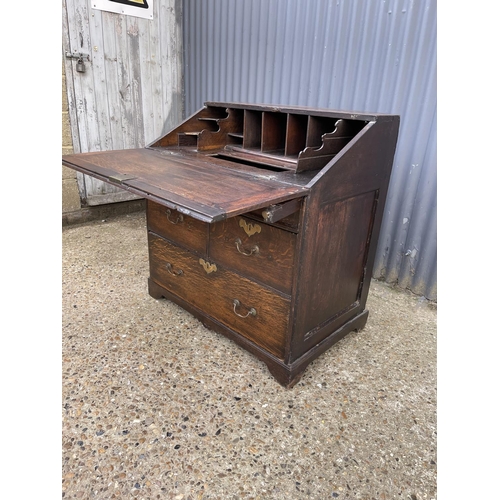 282 - A Georgian oak bureau, fitted to the interior with well. Three drawers