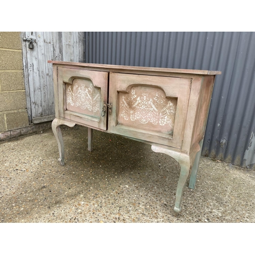 29 - A pink and white painted two door oak sideboard