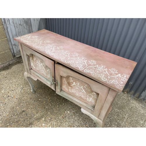 29 - A pink and white painted two door oak sideboard