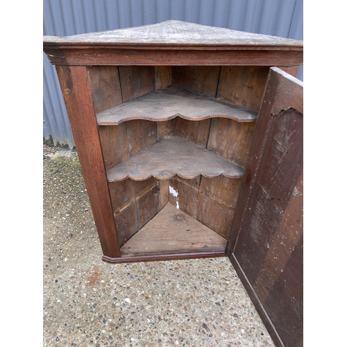 299 - An antique oak wall hanging corner cupboard