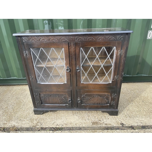 356 - An oak cabinet with leaded glass doors