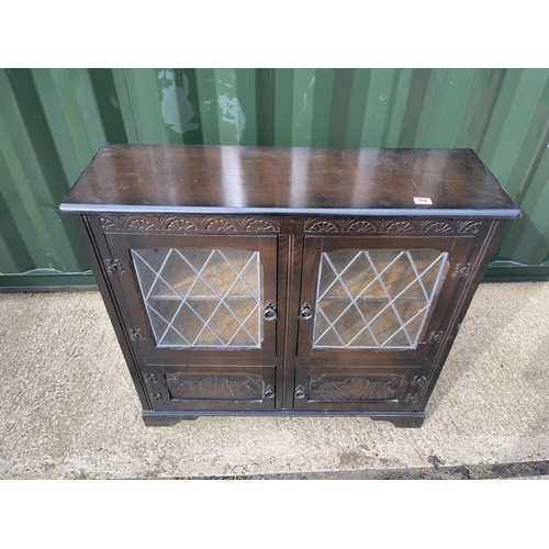 356 - An oak cabinet with leaded glass doors