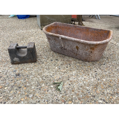 38 - A vintage heavy iron feed trough together with an iron weight