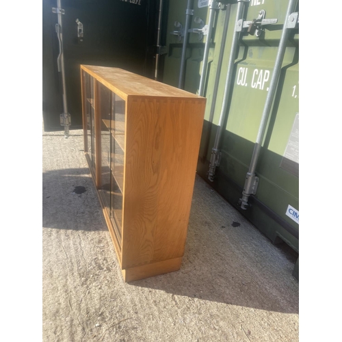 380 - A mid century light oak side by side glazed bookcase