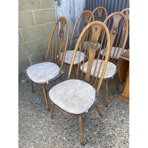 398 - An ercol golden dawn drop leaf kitchen table together with six swan back dining chairs