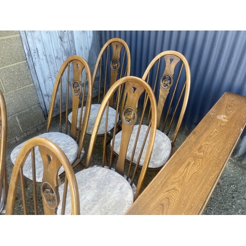 398 - An ercol golden dawn drop leaf kitchen table together with six swan back dining chairs