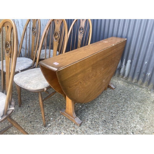 398 - An ercol golden dawn drop leaf kitchen table together with six swan back dining chairs