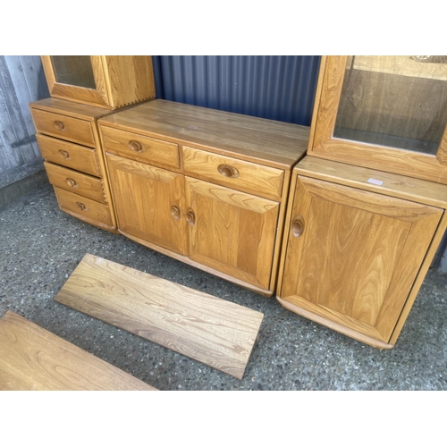 399 - An ercol light elm dresser with three section base with two glazed cabinet tops with two floating sh... 