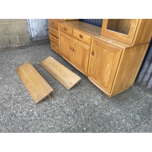 399 - An ercol light elm dresser with three section base with two glazed cabinet tops with two floating sh... 