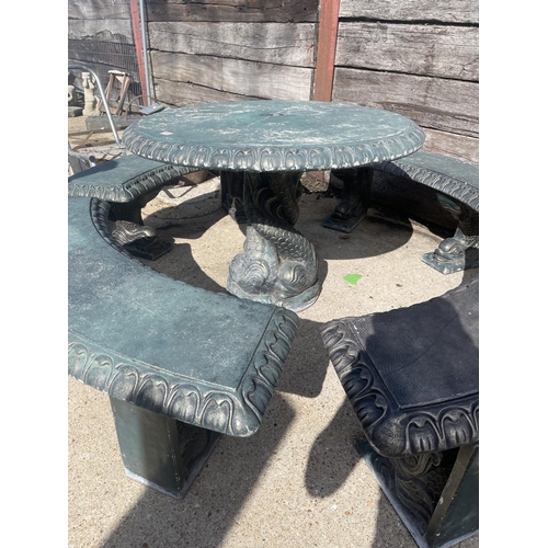 490 - A large green painted concrete circular garden table together with a set of four curved garden bench... 