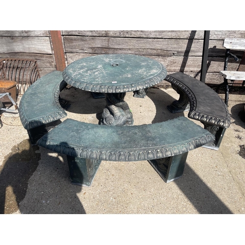 490 - A large green painted concrete circular garden table together with a set of four curved garden bench... 