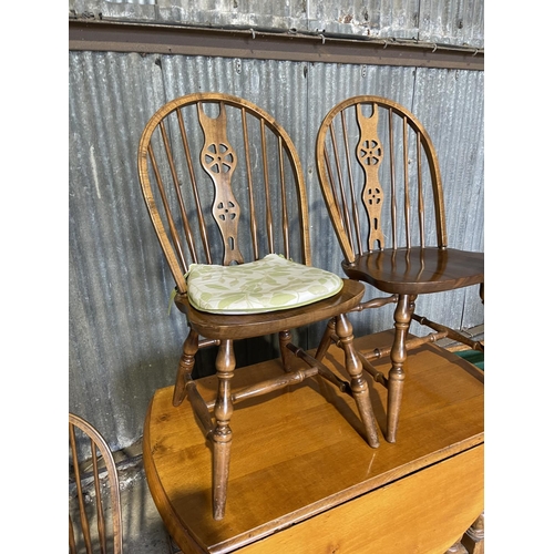 58 - An oak gateleg dining table with long drawer together with four wheelback dining chairs