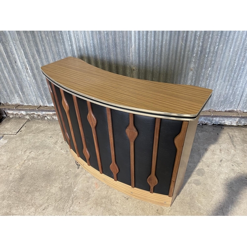 60 - A mid century cocktail bar unit with a formica top and teak and black vinyl to the front