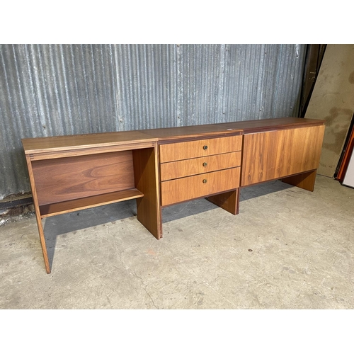 64 - A mid century teak bedroom set consisting of chest of three, desk with lift up top and ottoman