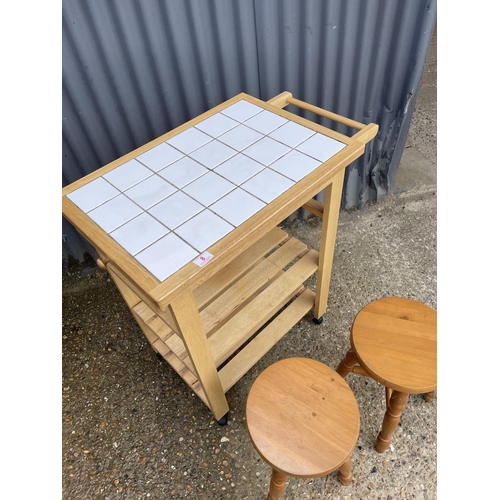 8 - A beech kitchen trolley together with two pine stools