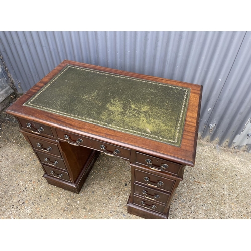 83 - A small mahogany pedestal desk with a green leather top